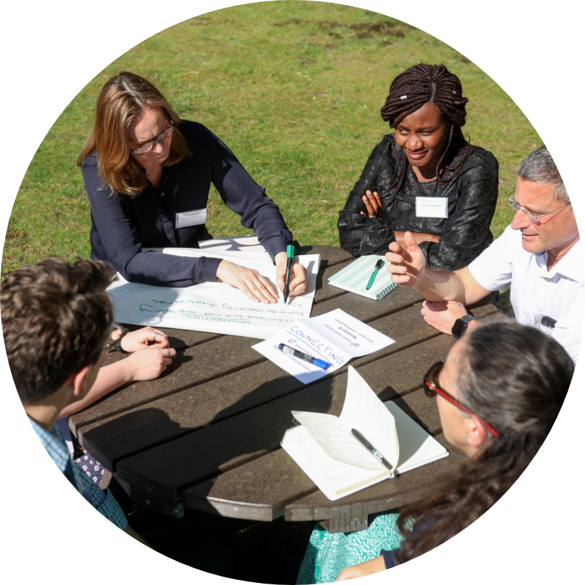 Image of group sat at table with notepads